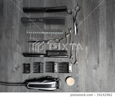 Set of professional hairdresser tools on grey background. Wooden table in barbershop. Working tool Set of professional hairdresser tools on grey background. Wooden table in barbershop. Working tool 54242962