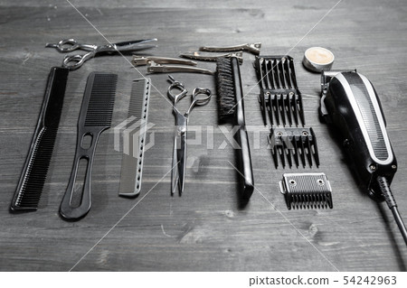 Set of professional hairdresser tools on grey background. Wooden table in barbershop. Working tool Set of professional hairdresser tools on grey background. Wooden table in barbershop. Working tool 54242963