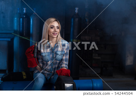 Girl with a welding machine. girl in a blue shirt Girl with a welding machine. girl in a blue shirt 54244504