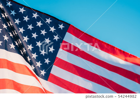 American flag in a blue sky, close up American flag in a blue sky, close up 54244982
