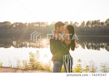 People, love and nature concept - Young beautiful woman and handsome man embracing each other over People, love and nature concept - Young beautiful woman and handsome man embracing each other over 54245547