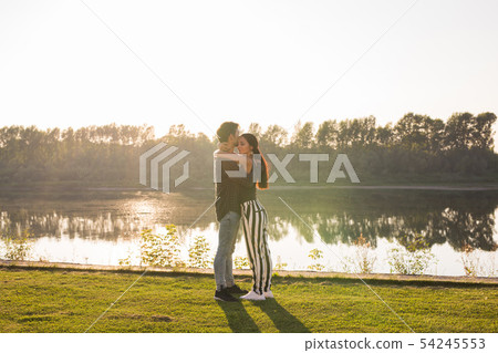 Romantica, nature and people concept - young couple kissing on the beach of lake and hugging 54245553