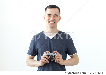 Vintage, photographer and people concept - handsome asian man with retro camera over white 54245641