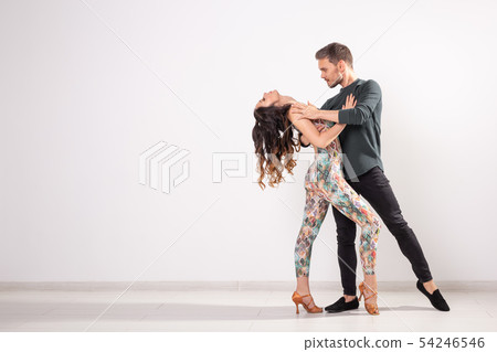Social dance, bachata, kizomba, tango, salsa, people concept - Young couple dancing over white 54246546
