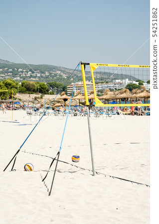 Beach Burley's net and the beach umbrella made of straw in the distance on the white beach in Majorca 54251862