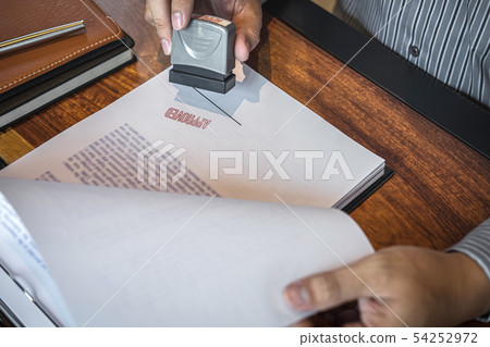 Hands of businessman stamp on paper document to 54252972