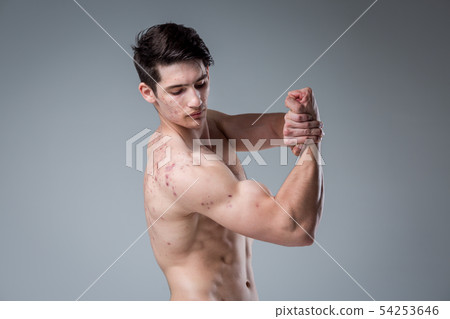 Studio portrait young Caucasian man on gray background posing. theme of puberty, problem skin, teen Studio portrait young Caucasian man on gray background posing. theme of puberty, problem skin, teen 54253646