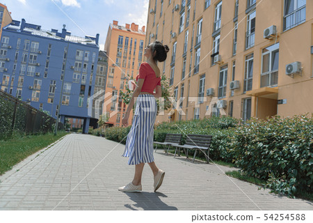 Beautiful young woman with take-away drink walking on the street Beautiful young woman with take-away drink walking on the street 54254588