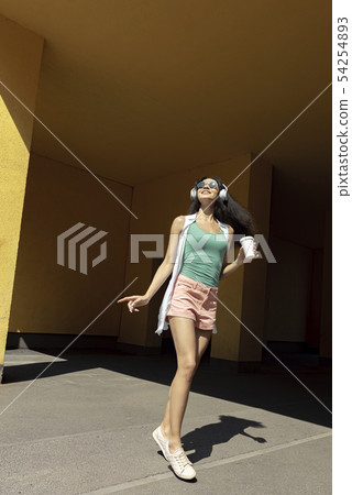 Pretty girl in wireless headphones enjoying music and moving to the rhythm 54254893