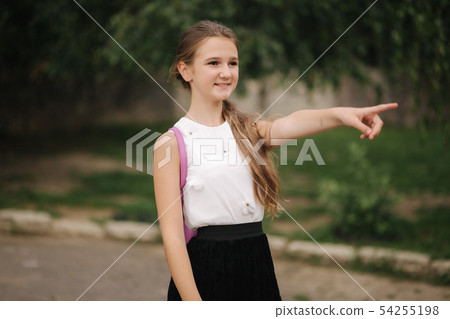 Young girl walking in the park with backpack 54255198
