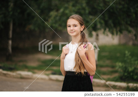 Young girl walking in the park with backpack Young girl walking in the park with backpack 54255199