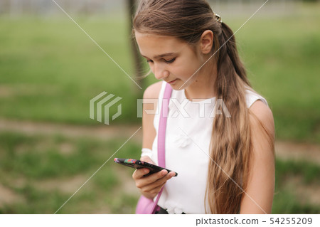 Young girl use phone during school break. Girl play online games 54255209