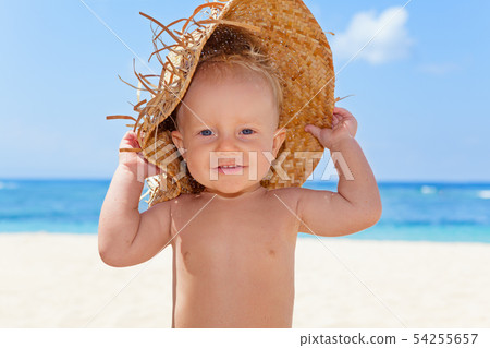 Happy baby boy in straw hat on sunny tropical Happy baby boy in straw hat on sunny tropical 54255657