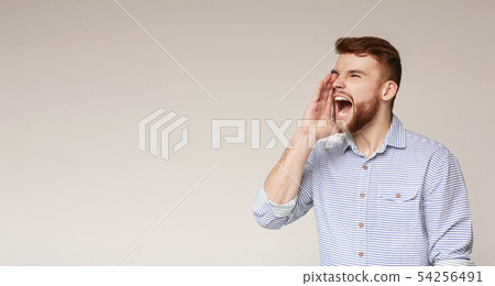 Crazy emotional man screaming over beige background 54256491
