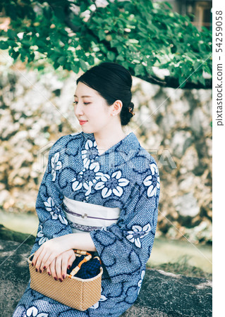 A woman in a yukata resting in the shade of a tree A woman in a yukata resting in the shade of a tree 54259058