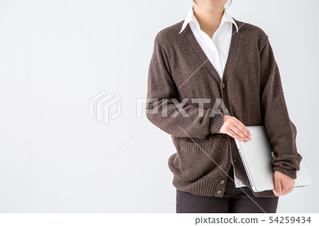 Woman in a cardigan on a white background is holding a laptop 54259434