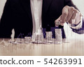 Business man putting coin on pile of money 54263991