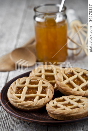 Fresh baked tarts with marmalade or apricot jam 54270337