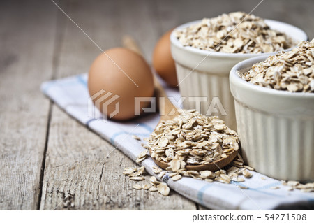 Fresh chicken eggs, oat flakes in ceramic bowl and Fresh chicken eggs, oat flakes in ceramic bowl and 54271508