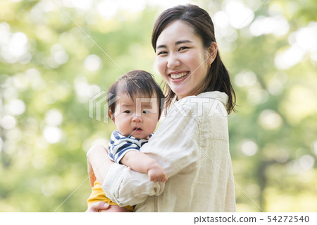 Young mother holding a baby Parenting Parenting Family Park Fresh green 54272540