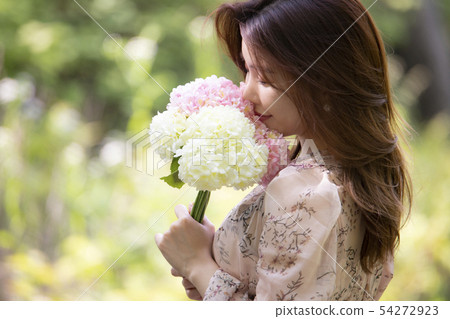A woman holding a blossom 54272923