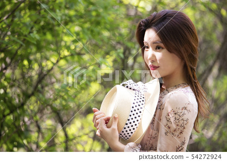 A woman holding a hat A woman holding a hat 54272924