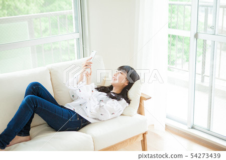 Young girl using smartphone in room 54273439