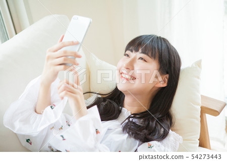 Young girl using smartphone in room 54273443
