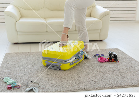 Vacation, travel and holidays concept - woman packing suitcase on background Vacation, travel and holidays concept - woman packing suitcase on background 54273655