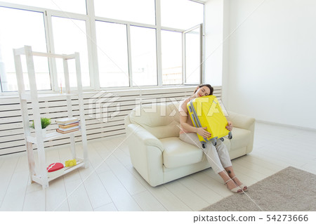 Trip, travel and holidays concept - young woman hugging her yellow suitcase 54273666