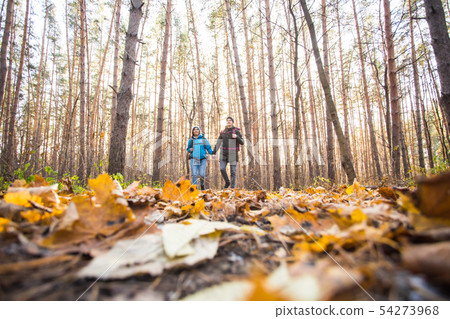 Adventure, travel, tourism, hike and people concept - smiling couple walking with backpacks over 54273968