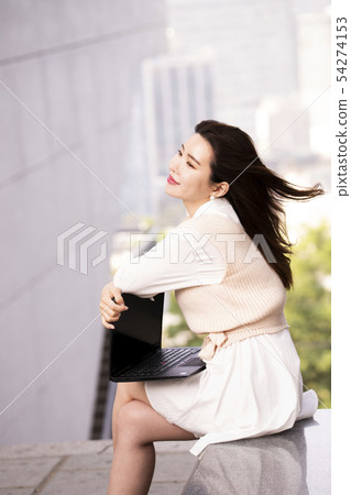 A woman with a laptop on her lap 54274153