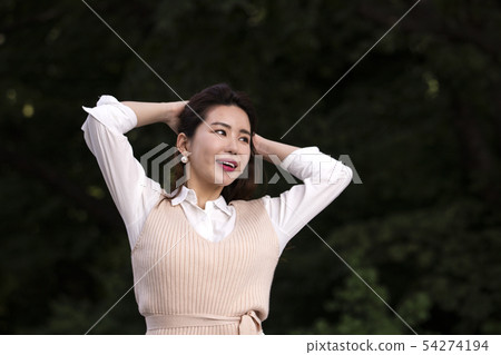 Woman holding her arm and touching her head 54274194