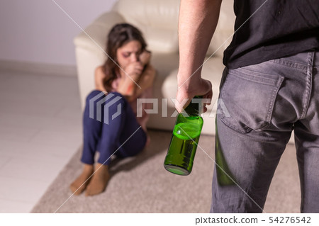 domestic violence, alcoholic and abuse concept - drunk man with bottle abusing his wife lying on the domestic violence, alcoholic and abuse concept - drunk man with bottle abusing his wife lying on the 54276542