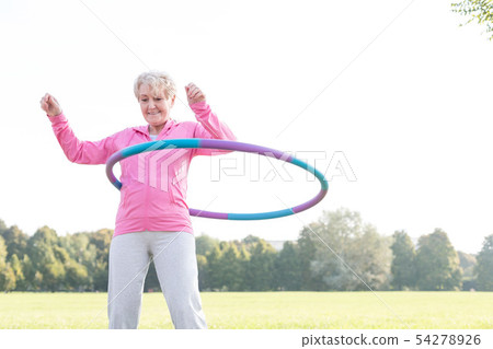Senior woman doing gymnastic with hula hoop Senior woman doing gymnastic with hula hoop 54278926