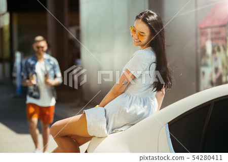Young couple preparing for vacation trip on the car in sunny day 54280411