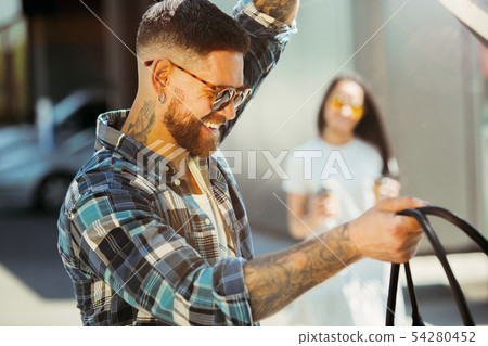 Young couple preparing for vacation trip on the car in sunny day Young couple preparing for vacation trip on the car in sunny day 54280452