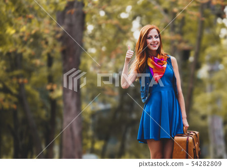 redhead girl with suitcase in the park. redhead girl with suitcase in the park. 54282809