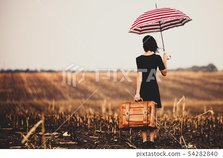 young woman with suitcase and umbrella 54282840