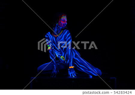 Young naked bodyarted woman in blue glowing ultraviolet paint moving and teasing. Sexy nude girl 54283424