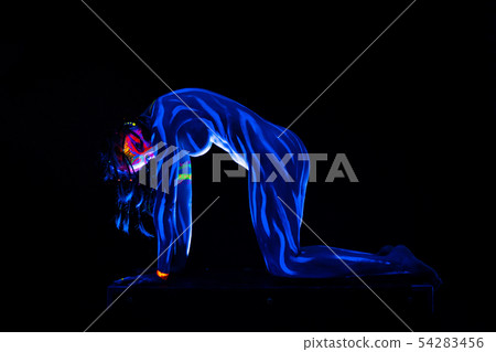 Young naked bodyarted woman in blue glowing ultraviolet paint moving and teasing. Sexy nude girl 54283456