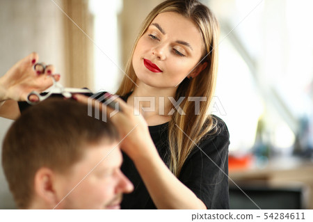 Young Woman Hairstylist Cutting Male Client Hair 54284611