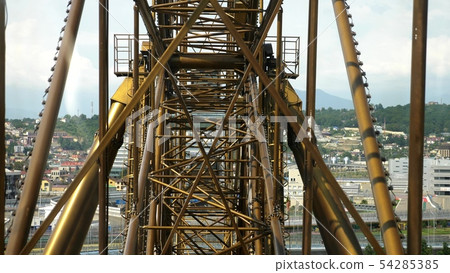 Metallic Mechanism of the Ferris wheel from the cabin, against the background of the city 54285385