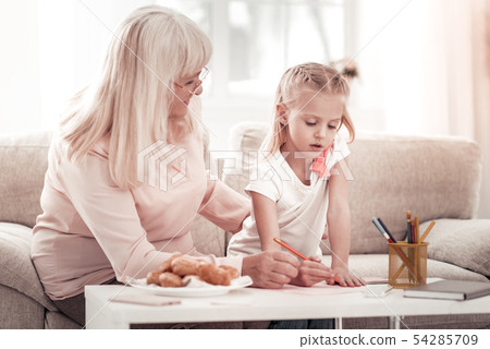 Smiling grandmother drawing pictures with her granddaughter 54285709