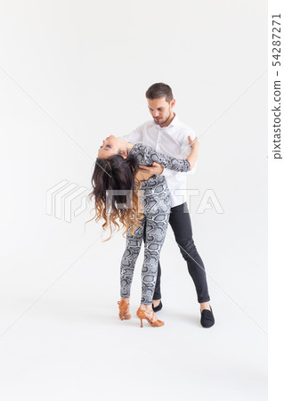 Social dance, bachata, kizomba, zouk, tango concept - Man hugs woman while dancing over white Social dance, bachata, kizomba, zouk, tango concept - Man hugs woman while dancing over white 54287271