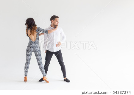 Social dance, bachata, kizomba, zouk, tango concept - Man hugs woman while dancing over white Social dance, bachata, kizomba, zouk, tango concept - Man hugs woman while dancing over white 54287274