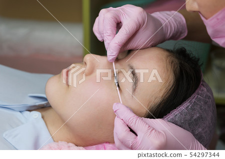 Eyelash Extension Procedure. Woman Eye with Long Eyelash Extension Procedure. Woman Eye with Long 54297344