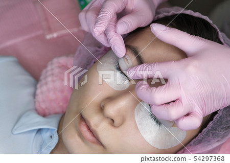 Eyelash Extension Procedure. Woman Eye with Long Eyelash Extension Procedure. Woman Eye with Long 54297368