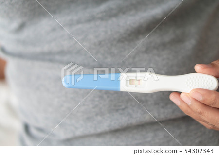 Closeup woman hand holding pregnancy test 54302343