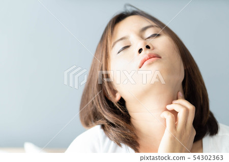 Closeup woman holding neck with pain after waking Closeup woman holding neck with pain after waking 54302363